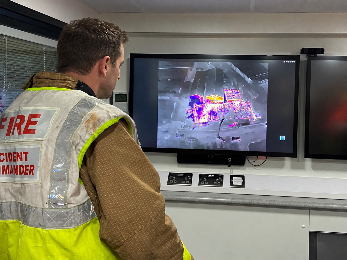 Fire incident commander reviewing aerial thermal imagery on a command unit monitor